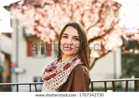 Spring portrait of pretty young woman posing outdoor