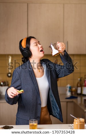 Cheerful woman fooling around in the kitchen after spending too much time indoors