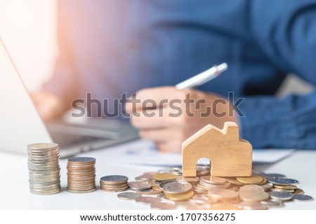 A businessman work form home and self quarantine while Coronavirus, Covid-19 pandemic situation. Concept of Property investment and house mortgage financial. A young man planning for refinance dept. Royalty-Free Stock Photo #1707356275