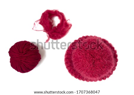 Isolated hat and yarn balls. Bright red knitted hat on the white background. Flat lay. Top view. Knitting with love.