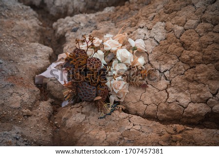 Wedding decorations. A wedding bouquet of dried lotuses and roses lies on clay. Beautiful bouquet for a lavish ceremony