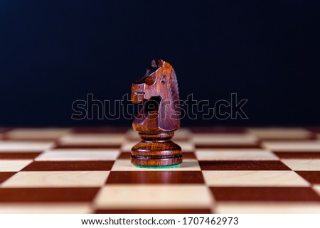 black chess knight on a chessboard on a black background