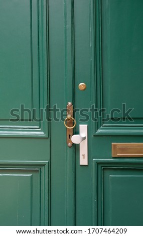 Old metal door handle lock on green wooden door. Door knob