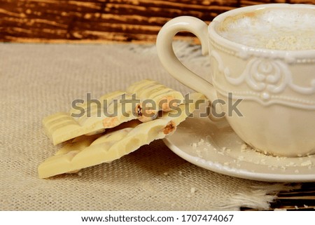 coffee with white milk froth and pieces of white chocolate
