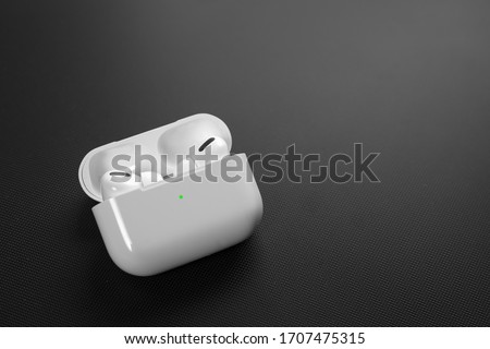Air Pods Pro. with Wireless Charging Case. New Airpods pro on black background. Airpods Pro. Copy space Royalty-Free Stock Photo #1707475315