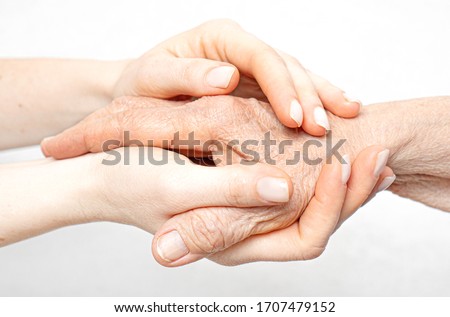 Helping hand for the elderly concept with young hands holding old hand.  Royalty-Free Stock Photo #1707479152