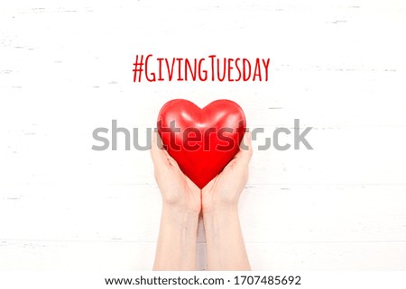Giving Tuesday is a global day of charitable giving after Black Friday shopping day. Charity, give help, donations and support concept with text message sign and red heart in woman hands Royalty-Free Stock Photo #1707485692