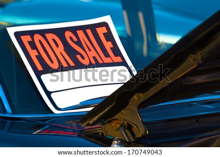 Generic for sale sign mounted on the windshield of a used car.