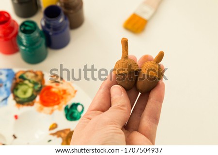 The child is playing with stones from children’s activities.kid painting acorn for her handcraft picture for nursery or kindergarten activity concept time.