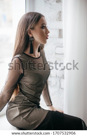 Portrait of beautiful young brunette girl with makeup  in grey fashion clothes 