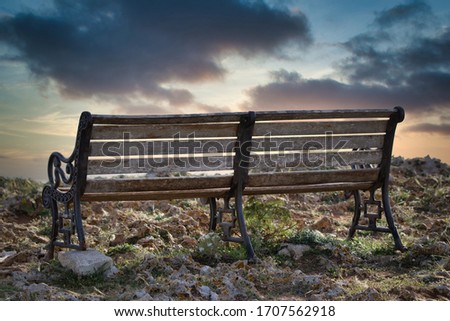 A bench in front of a sunset