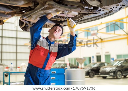 The repairman is checking the car for maintenance. Damaged engines undergo maintenance by expert technicians. Auto Service Concept