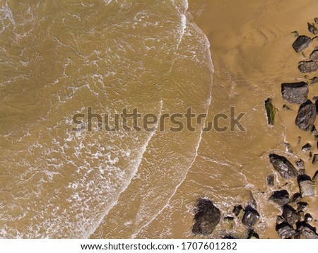 Ocean beach, sand, waves and stones. Photo texture for design.