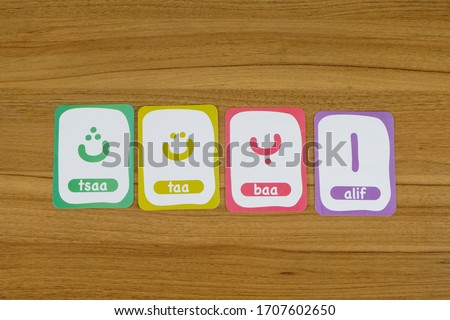 Arrangement of Arabic letters and spelling  cards on a wooden table for children's games (top view)