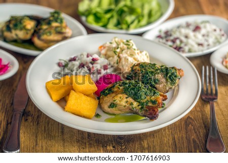 
A baby chicken called galeto in Brazil served with herbs, potato salad, wine onion, fried polenta, rice with dried meat and potato salad
