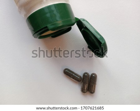 photo of the medicine container and capsules with white background