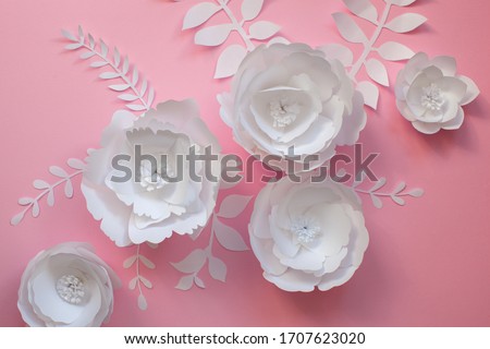 Paper craft and cutting flowers. Handmade art work on pink background. Close up. 