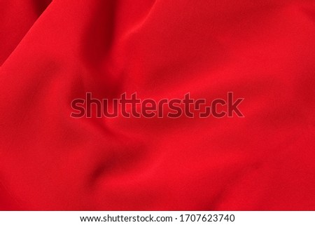 Red, scarlet Abstract background. Red, scarlet Synthetic fabric texture, background. Red, scarlet fabric.