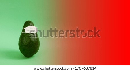 Green avocado in a white medical mask on an empty background for inscriptions. The concept of protecting a person health from the virus, bacteria and allergen. Copy space, front view, banner