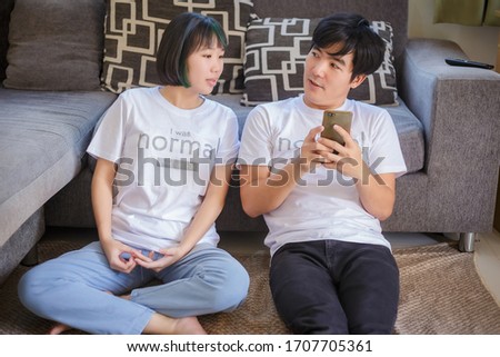 Father and daughter watching a video on the smartphone.