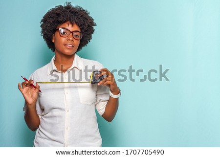 young black woman wearing glasses with a measuring tape in hand