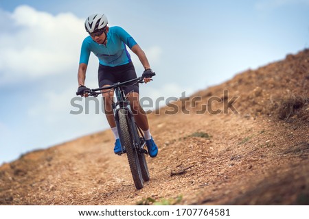 Mountain biker cycling, training and going up a steep climb. Royalty-Free Stock Photo #1707764581