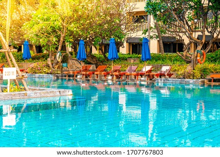 Beautiful umbrella and chair around swimming pool in hotel and resort - vacation and holiday concert