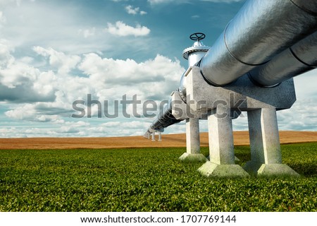 Pipeline on the street in the field, the transportation of oil and gas through pipes. Technology, politics, raw materials, economics. Copy space. Mixed media Royalty-Free Stock Photo #1707769144