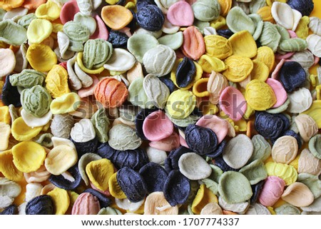 Multicolored italian pasta.  Various colors conchiglie pasta with spinach, beets and carrots. Top view. Creative food background.