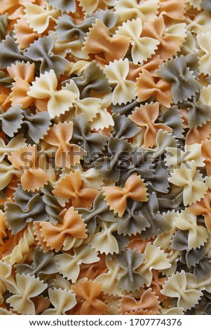 Colorful Italian pasta background. Various colors of bow tie farfalle pasta. Top view.Creative food background.