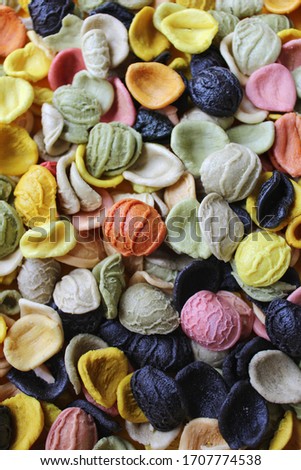 Multicolored italian pasta.  Various colors conchiglie pasta with spinach, beets and carrots. Top view. Creative food background.
