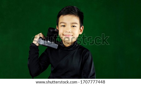 Younger photographer. Photographer makes beautiful pictures of different famous models. He wears a nice long-sleeved black shirt. He is carrying a camera to take pictures as his favorite hobby.