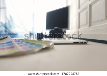 
Work table with laptop, photo camera and color palette.