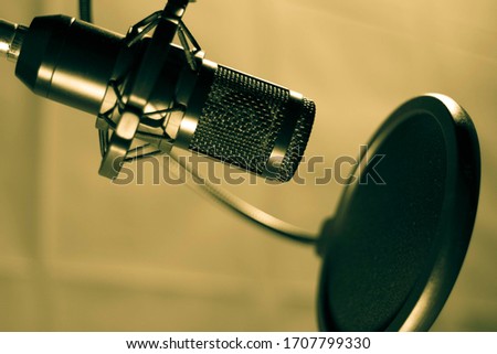 A black microphone is used for recording audio.
