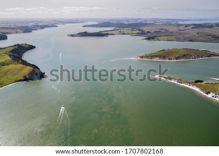 Aerial view on Kaipara Harbour with a motorboat on  clear water in Northland, New Zealand. 