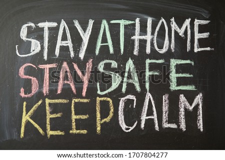 Inscription stay at home stay safe keep calm. Outbreak Warning. written white chalk on blackboard in connection with epidemic of coronavirus worldwide. Covid 19 pandemic Text on black background