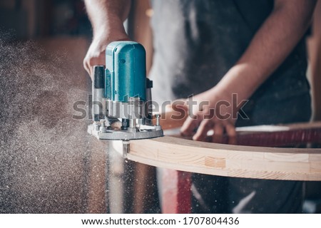 Joinery, woodworking and furniture making, professional carpenter cutting wood in carpentry shop, industrial concept Royalty-Free Stock Photo #1707804436