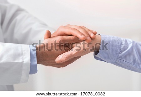 Older people healthcare support concept. Doctor holding hand of senior woman at medical visit, close up Royalty-Free Stock Photo #1707810082