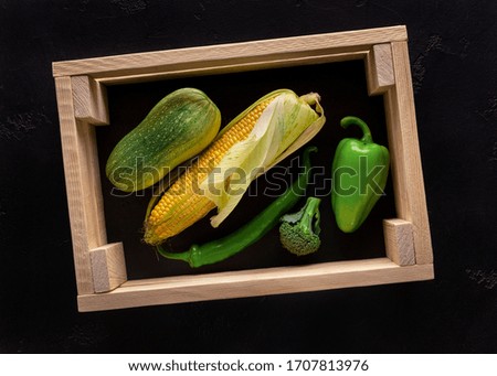 Vegetarian concept. Fresh peppers in wooden box vegetables in eco wooden box, black background