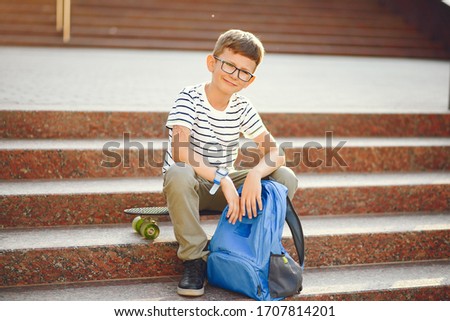 Boy with a skate. Pupil with a backpack.