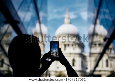 Man photographing with smart phone. Tourist taking picture of St. Paul's Cathedral in London, United Kingdom. 
