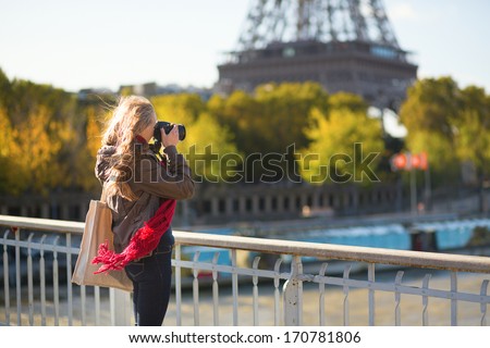 Young tourist in Paris taking picture of the Eiffel tower