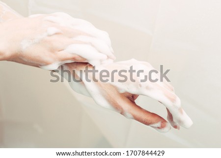Female hand in the foam. Personal hygiene with antibacterial soap