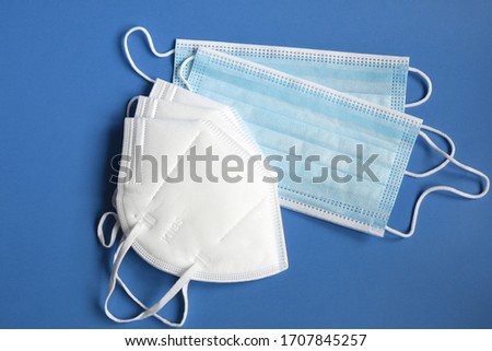 white KN95 or N95 mask with antiviral medical mask for protection against coronavirus on blue background. Surgical protective mask. prevention of the spread of virus and pandemic COVID-19. Royalty-Free Stock Photo #1707845257