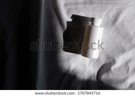 White bottle on a light fabric background and shadow. Chemical Solvent Bottle with Cap
