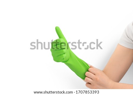 Hand with green rubber protective glove isolated on white gesturing thumbs up, ok, yes, positive. Signs of gestures (language), gloves cleaning, kitchen gloves.