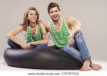 Young couple sitting and relaxing on black sofa 