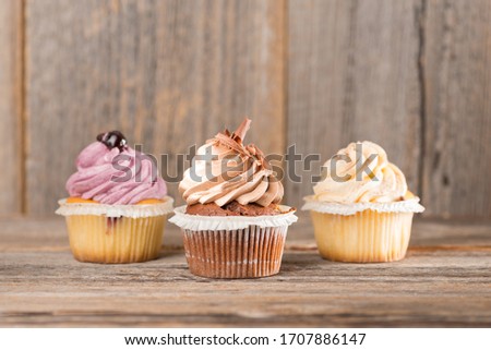 sweet different cupcakes on wooden background Royalty-Free Stock Photo #1707886147