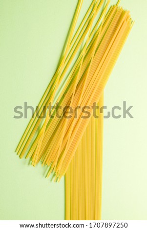 Italian pasta, spaghetti crossed on a green background.
