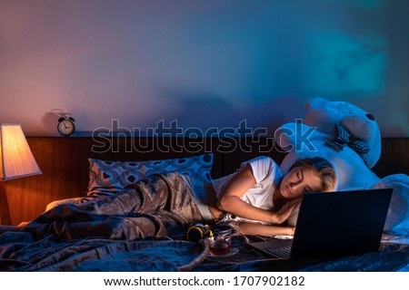 Young brunette woman sleeping next to her laptop computer



